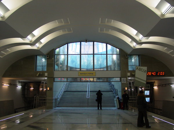 DSC06196.JPG (1.61 МБ) 3069 просмотров Действующий западный вестибюль. Выход к парковке. Даже любопытствующих почти нет. На указателе "выход в город" нет ни одного объекта, к которому можно выйти! (как и на "Битцевском Парке"; кажется это впервые в истории ММ). Впрочем, на поверхности объектов тоже нет, кроме 17й больницы, которая всё равно ближе к восточному вестибюлю. Зато есть освещение естественным светом, просвечивающим насквозь витраж с тоненькими силуэтами деревьев.